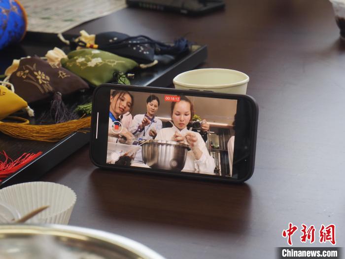 图为留学生用手机将自己制作青团的过程记录下来。　李娇阳 摄