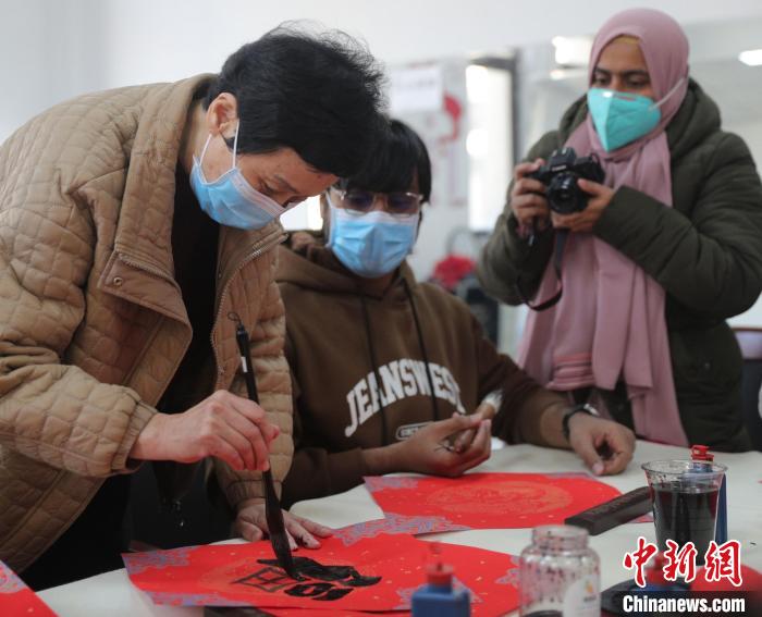 图为书法爱好者指导外国留学生书写福字。　曹建雄 摄