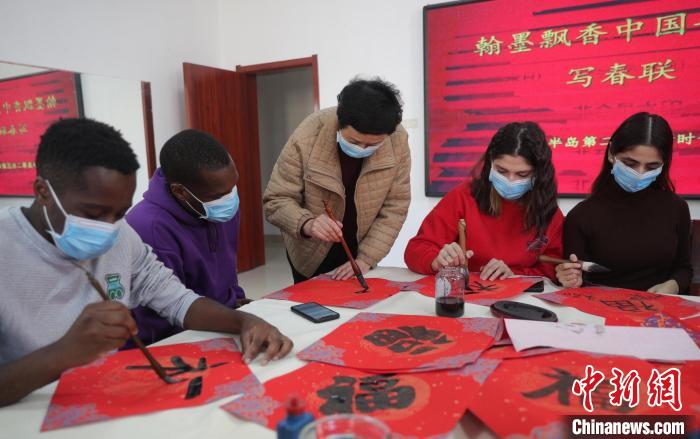 图为书法爱好者指导外国留学生书写福字。　曹建雄 摄