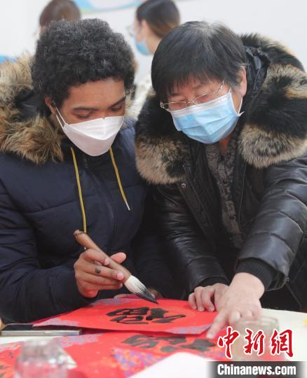图为书法爱好者指导外国留学生书写福字。　曹建雄 摄