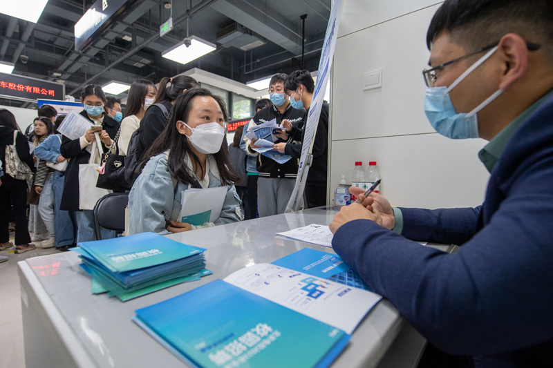 4月12日，在北京市管企业2023春季校园招聘活动现场，求职学生与招聘单位代表（右一）交流。人民网记者 翁奇羽 摄